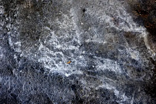 White, brown, and grey swirl patterns with a rocky texture.